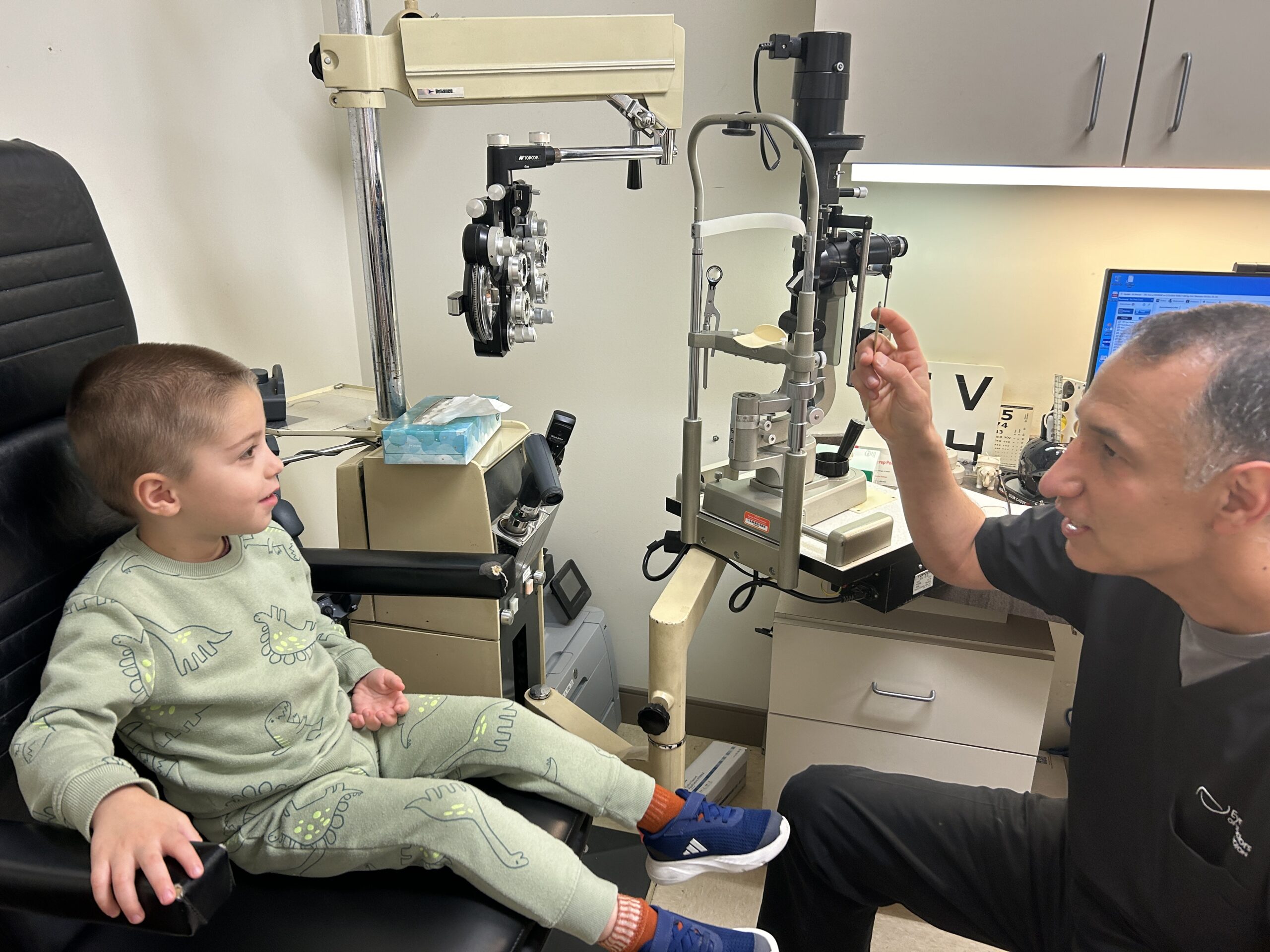 Doctor giving child eye exam at the doctor's office.